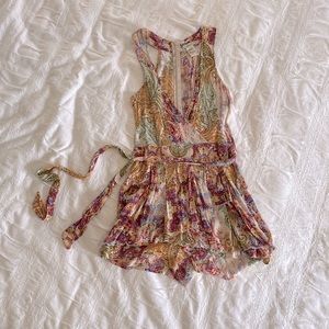 Colorful romper with zipper up the back and flattering waist tie. Like new.